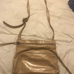 A tan crossbody Hobo bag.